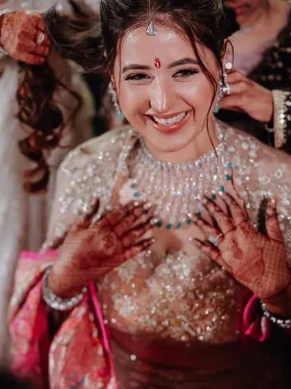 A candid moment of joy. This photo captures the bride's happiness as she gets ready for her big event.