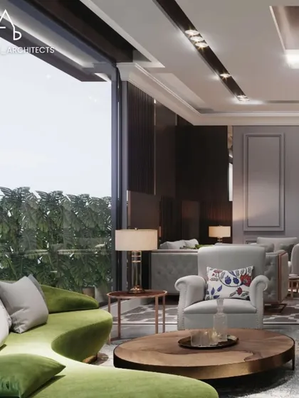 In this Rajokri farmhouse living room, I used a vibrant green curved sofa as a centerpiece, set against a backdrop of floor to ceiling windows. The design emphasizes natural light and an open, airy feel, connecting the elegant interiors with the lush greenery outside.