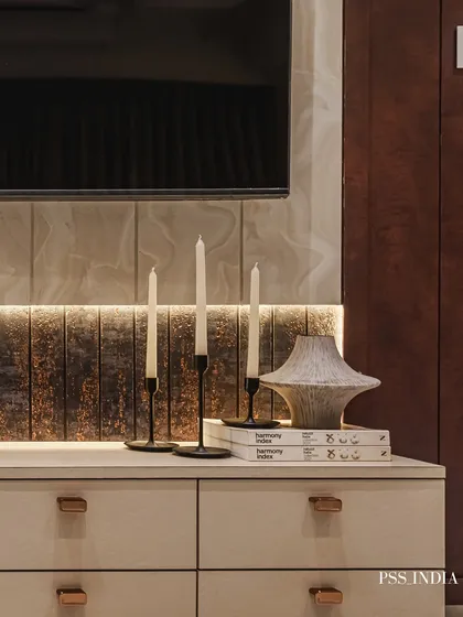 Delicate accents are the quiet details that make a space feel complete. Here, slim black candle holders and a textured ceramic vase create a simple, elegant composition on a media console.