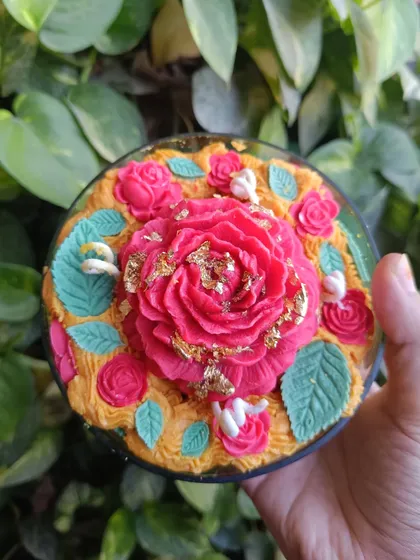 A top-down view of the rose garden candle, held in hand.