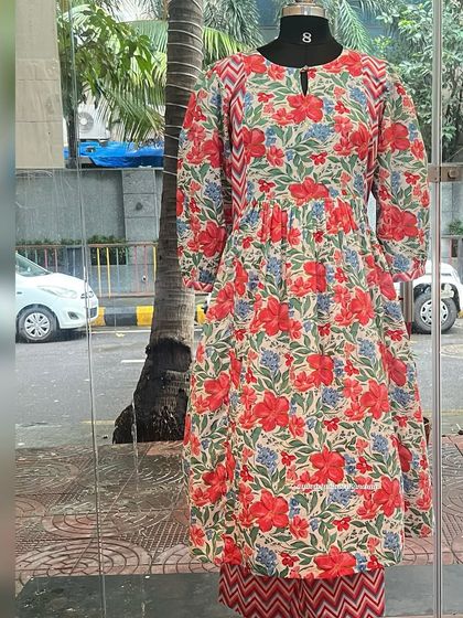 A mannequin shot of our festive red and blue floral printed kurta set. This pure cotton outfit is perfect for celebrating in style.