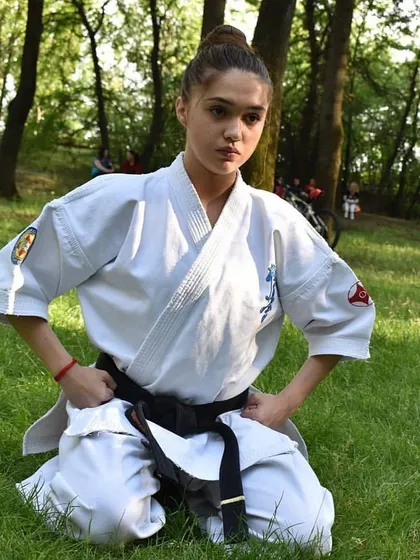 A moment of quiet focus. A black belt student kneels in a meditative pose, reminding us that martial arts is as much about mental discipline as it is about physical skill.