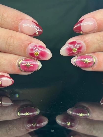 A full view of the stunning red watercolor and gold celestial nail art.