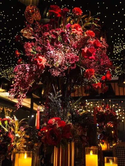 A centerpiece of floral opulence. This arrangement of rich red blooms under a starry night ceiling created a dramatic and elegant focal point for the reception tables.