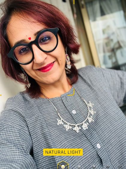 A selfie in natural light, showing the details of my silver necklace and a happy red bindi.