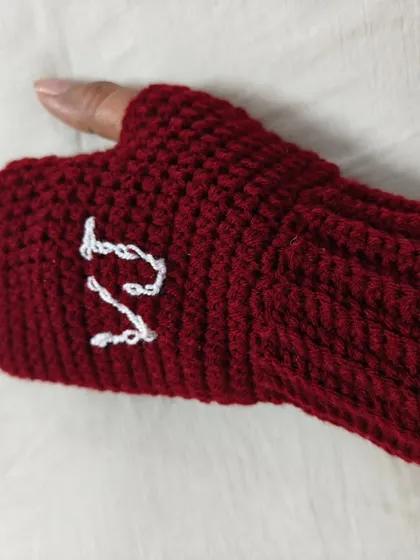 A close-up of the personalized maroon gloves, showing my initial 'V' for Vanya Yarn Designs. I can add any initials you want to make your pair truly special.