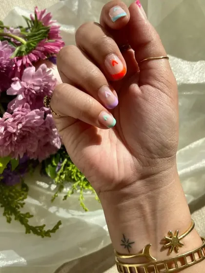 A close-up of the statement thumb nail from the Valentine's set, with a tiny pink heart on a neon orange tip.