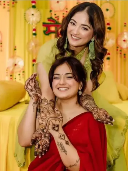 A fun moment between sisters at a mehandi ceremony, both adorned with my henna designs.