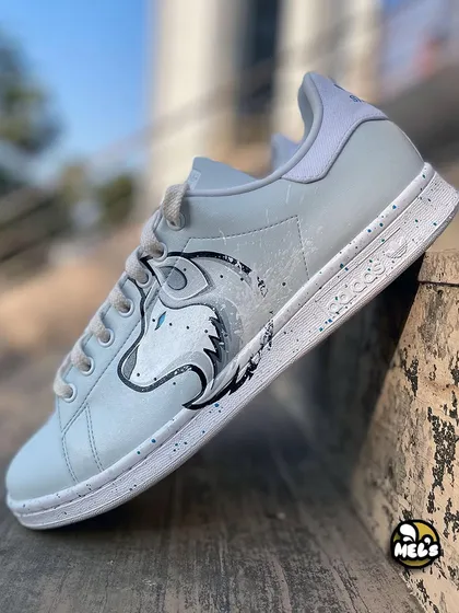 A full side view of the white wolf custom Adidas sneaker.