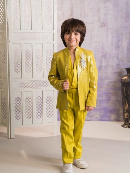 For a bold and festive look, I created this all yellow Indo-western suit. The jacket is made from a sequined fabric and is adorned with a decorative brooch.