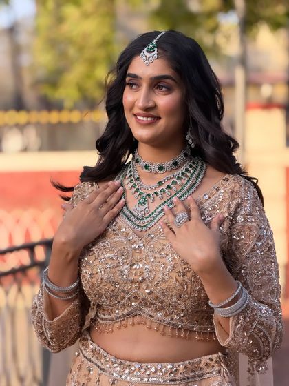The bride is adjusting her necklace, and her soft, wavy hair falls beautifully over her shoulders. This style is perfect for a modern, elegant bride.