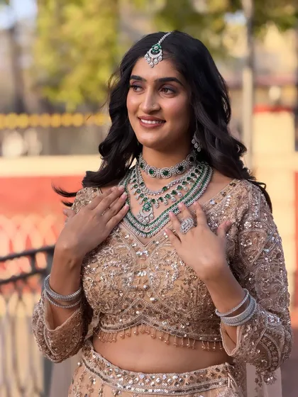 The bride is adjusting her necklace, and her soft, wavy hair falls beautifully over her shoulders. This style is perfect for a modern, elegant bride.