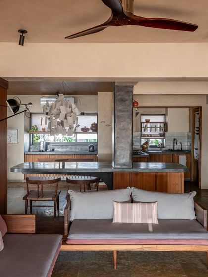 Here you can see how the open kitchen, dining, and living areas flow into one another. The cantilevered table, built around the central column, becomes the heart of the home where the family gathers.