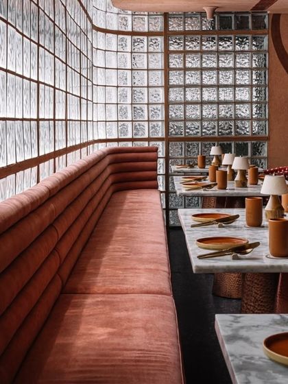 An intimate dining setup at Idylll, where the texture of the lime plaster walls and the soft glow of table lamps create a warm and inviting mood.