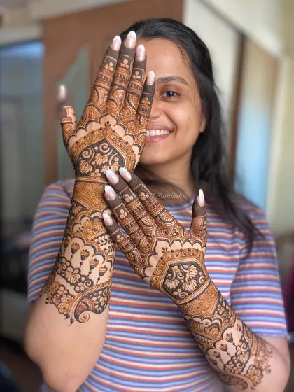 A happy client posing with her beautiful and unique engagement mehendi.
