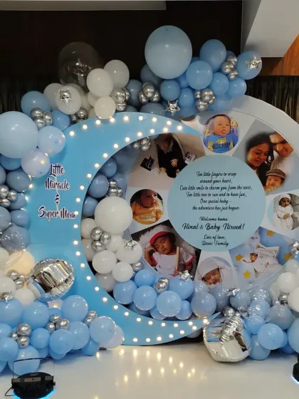 I can make your celebration extra personal by including your family photos, like in this moon-themed backdrop. It's a beautiful way to share your journey and joy with guests, surrounded by a lovely blue and silver balloon arrangement.