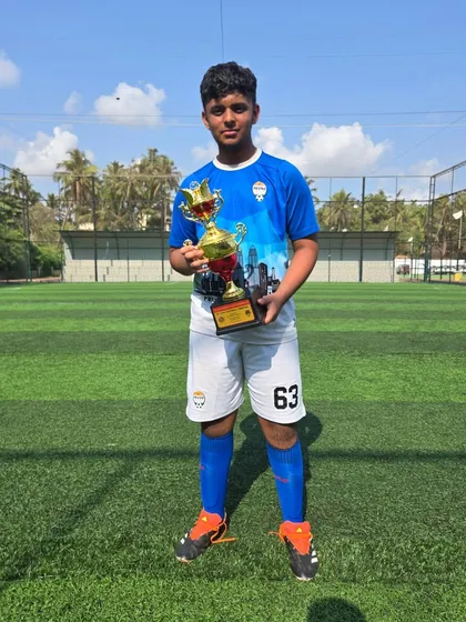 A U14 player showing off his championship trophy.