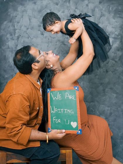 Welcoming a new member to the family. This studio maternity shoot includes the older sibling and a chalkboard sign, making it a joyful announcement for the whole family.