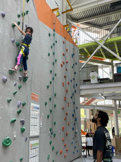 A young climber being watched by her belayer. Our staff and community create a supportive environment for kids to thrive.