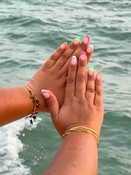 When clients send you beautiful pictures of your work. These rainbow French nails look stunning against the backdrop of the ocean.