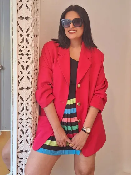 Boot season is here. A colorful striped skirt is balanced with a black top and a bold red blazer for a vibrant winter look.