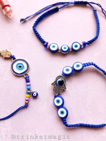A trio of beautiful evil eye bracelets, perfect for Rakhi or friendship bands. Each one has a unique design, from a multi-eye band to a Hamsa hand, all on adjustable blue cords.