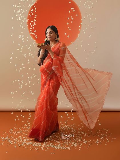 Holding a traditional diya, or lamp, she symbolizes light and hope. This is a powerful and culturally rich pose for a maternity photoshoot.