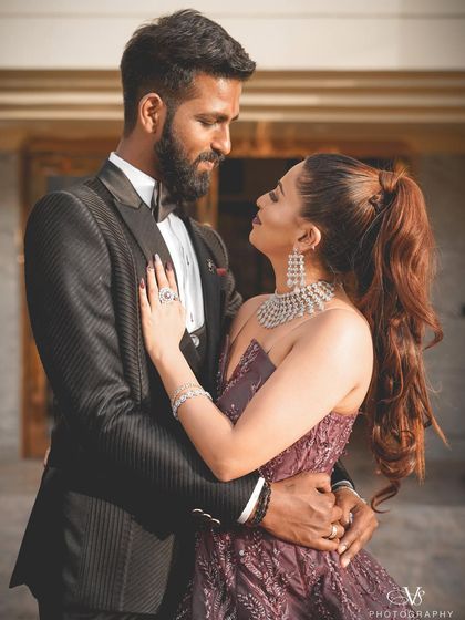 A classic, romantic portrait of the engaged couple. The groom is dressed in a sharp tuxedo and the bride in a gorgeous gown, capturing the elegance of the occasion.