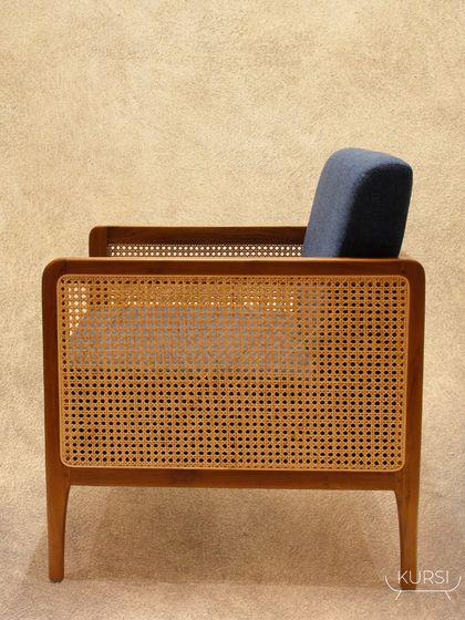 A handcrafted single-seater teak wood sofa. This piece combines a durable teak frame with woven rattan sides and plush cushions, and can be fully customized to your needs.