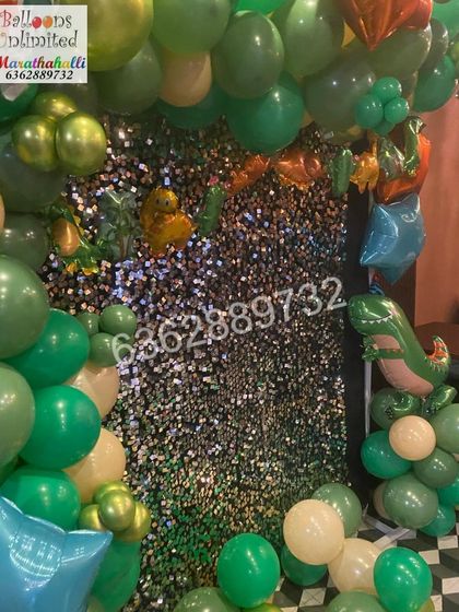 A dinosaur theme with a dark, sparkling shimmer wall that makes the green and gold balloons pop.