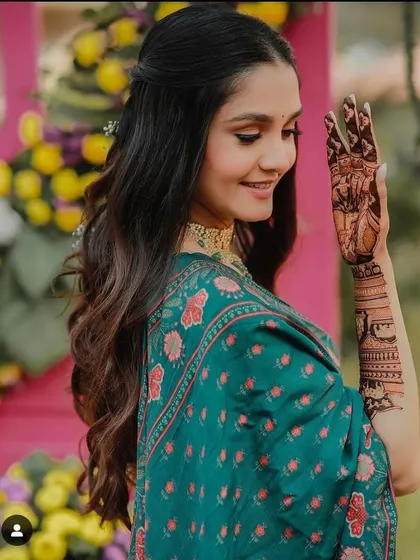 A candid shot of a beautiful bride, smiling as she looks at her intricate mehndi. These are the moments to cherish.