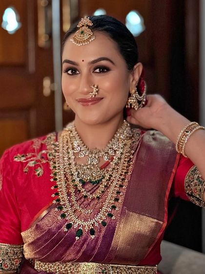 A candid moment showing the client adjusting her earring, highlighting the intricate details of her look.