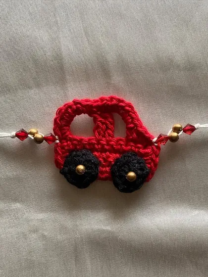 This cute red car Rakhi is another one of our custom designs for kids. The beaded details add a little extra sparkle to the handmade crochet car.
