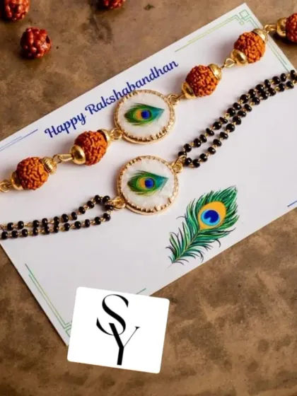 Tradition meets style with this Rudraksha and peacock feather charm Rakhi set. The bhai rakhi and bhabhi lumba bracelet are designed to complement each other perfectly.