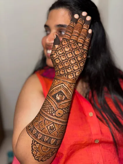 Another happy bride with her intricate grid-patterned mehendi, personalized with a small motif.