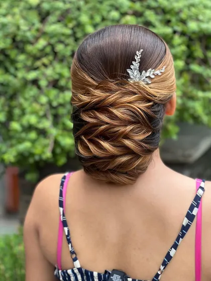 Another angle of the traditional low bun with highlights, finished with a crystal accessory.