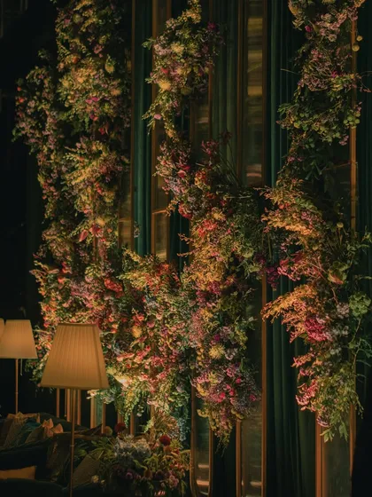 A wall of emerald green drapes was adorned with cascading floral installations, creating a lush, vertical garden effect that was both dramatic and beautiful.