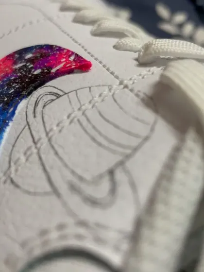 The initial pencil sketch of the Saturn design on the sneaker, right before painting begins.