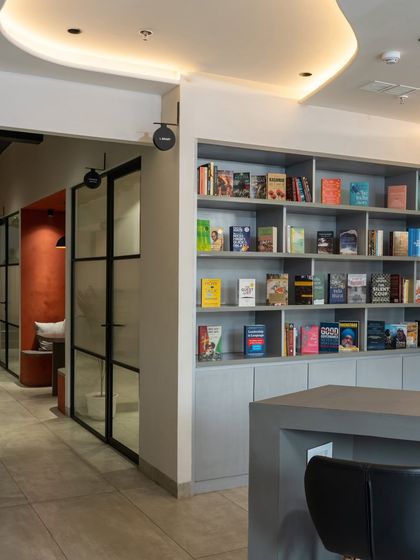 The library wall is visible from the main corridor, encouraging staff and visitors to browse the book collection.