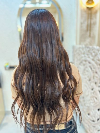 An olive ashy brown hair colour styled in beautiful, soft waves. This unique shade is both earthy and chic.