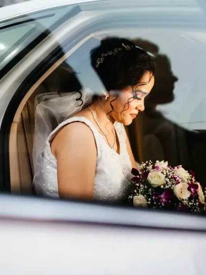 A beautiful play of shadows and reflections on the wedding car, with the bride's silhouette visible inside.