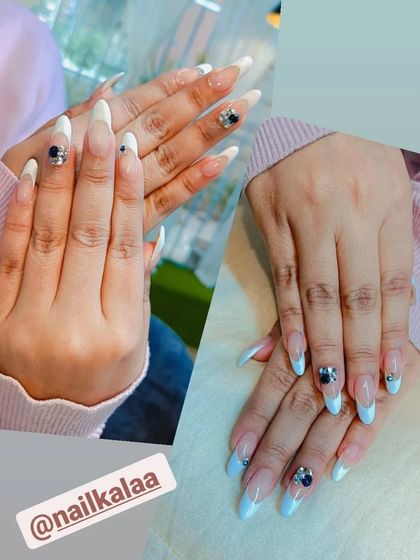 A beautiful set of long, stiletto nails combining a soft blue ombre with classic white French tips. The look is elevated with stunning 3D black and silver rhinestone flowers on the accent nails.