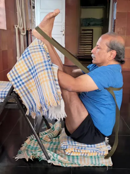 A seated leg lift using a chair and strap.