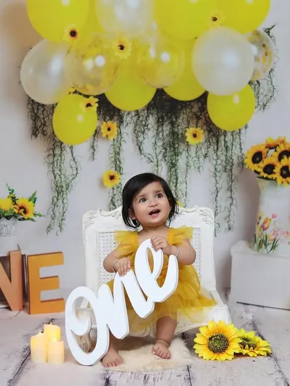 The birthday girl proudly holds up the "one" sign, a key moment in any first birthday photoshoot that marks this incredible milestone.