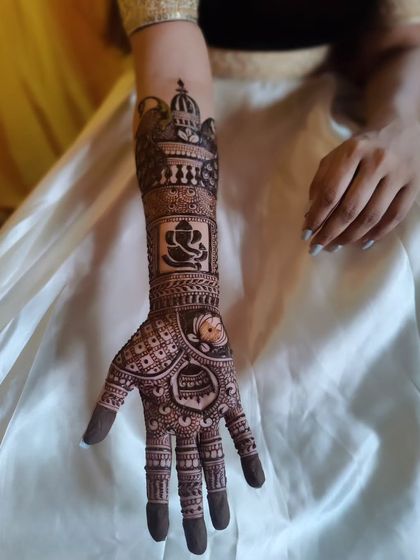A single hand from a bridal design, showcasing a bold Ganesha motif for good luck and blessings.