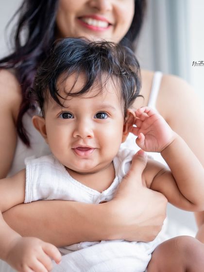 A close-up of a baby being held by their mother.