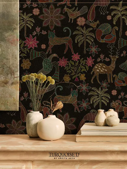 The Sundarban Jaal wallpaper, with its colorful, stitched-style animals and plants against a black background, creates a playful yet sophisticated feature wall. It pairs beautifully with neutral, rustic decor.