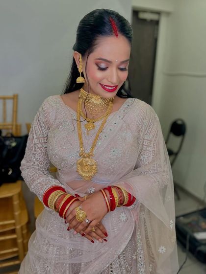 For her reception, this bride opted for an elegant and sophisticated look. I created a soft smokey eye with a bold red lip and a chic hairstyle, perfect for celebrating as a newlywed.