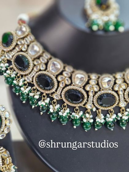 A detailed view of the choker, showing the contrast between the black stones, white ADs, and green beads.