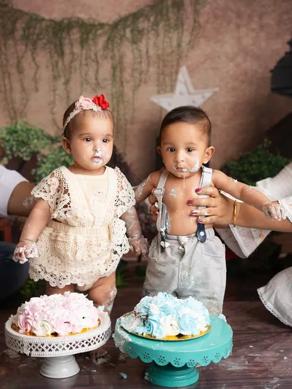 Double the trouble, double the fun. A half birthday cake smash for twins is twice as messy and twice as cute.